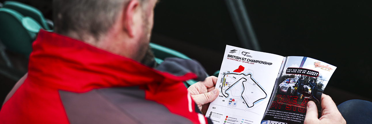 A British GT fan reading the programme at Silverstone