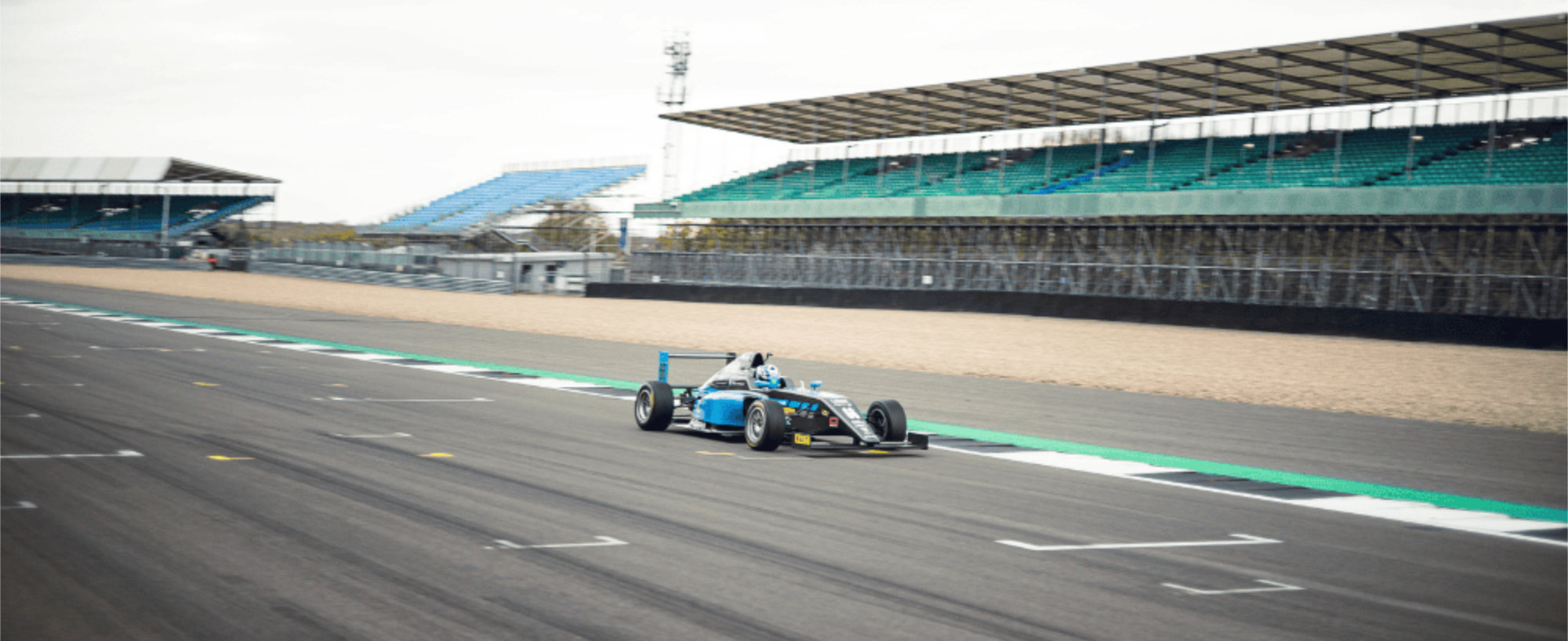 Chloe Grant on track at Silverstone in a GB4 car, driving towards the camera at speed on the National Pits Straight