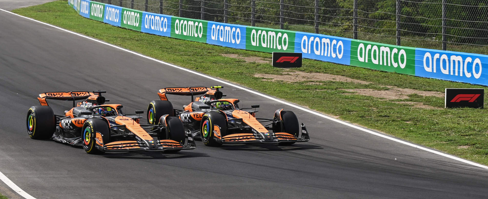 mclaren cars racing wheel to wheel going into the corner