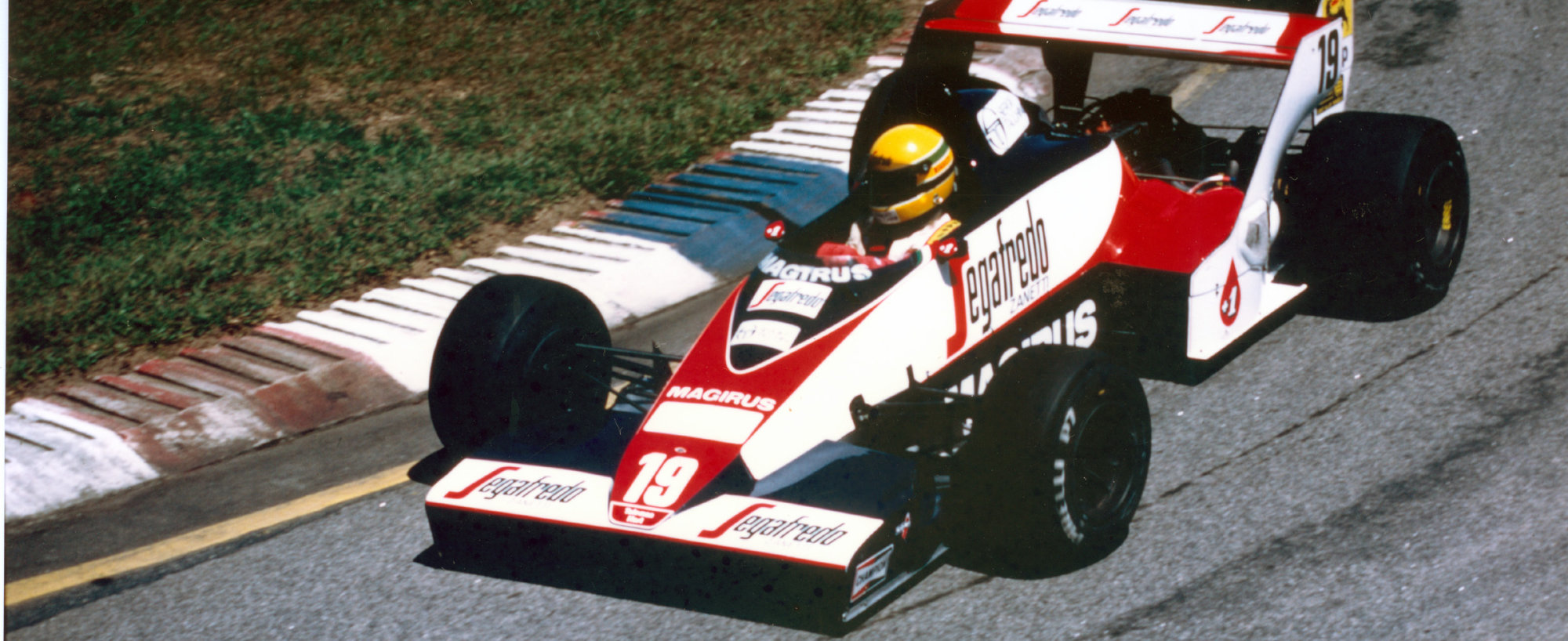 Ayrton Senna's Toleman on track, driven at the Brazilian Grand Prix. Car is going around a corner.
