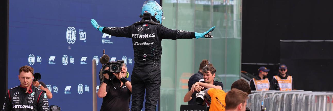 Russell striking a T pose on his car after getting pole in Canada