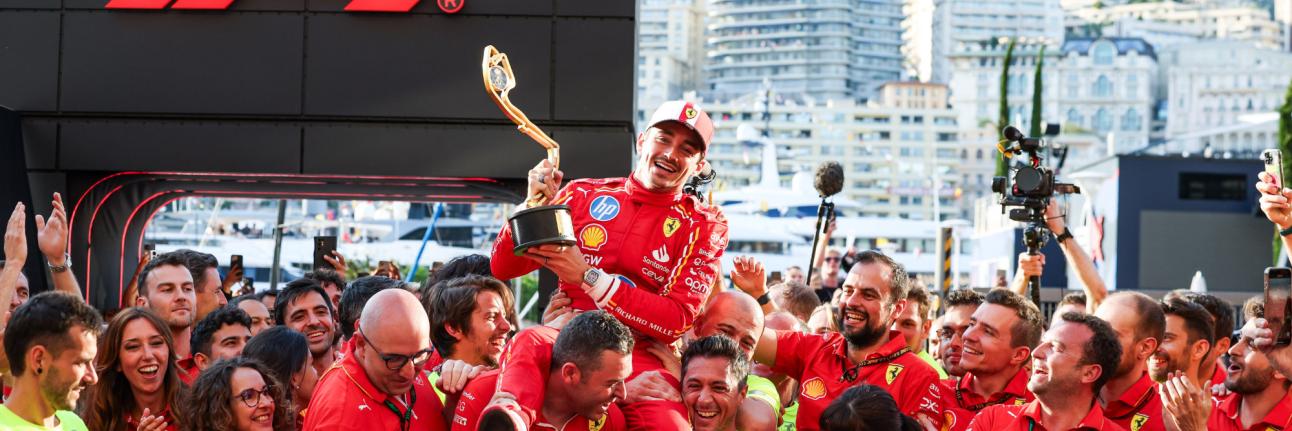 charles leclerc held up by the ferrari team at the monaco grand prix, holding his first place torphy. 