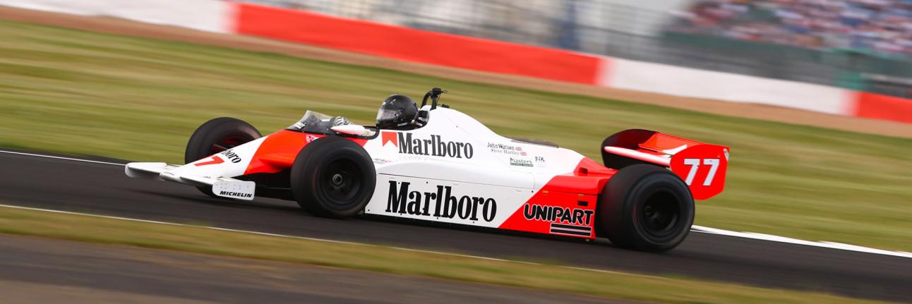 Red and white classic F1 car racing at The Classic, Silverstone