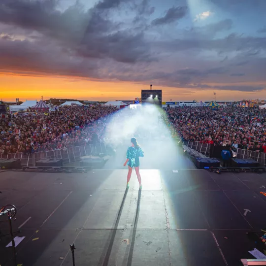 Performer on Silverstone Festival mainstage, with bright spotlight illuminating her