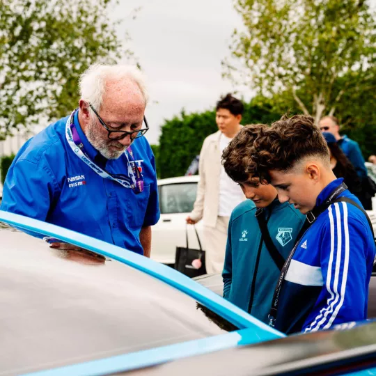 young festival attendees talking to car club car owner